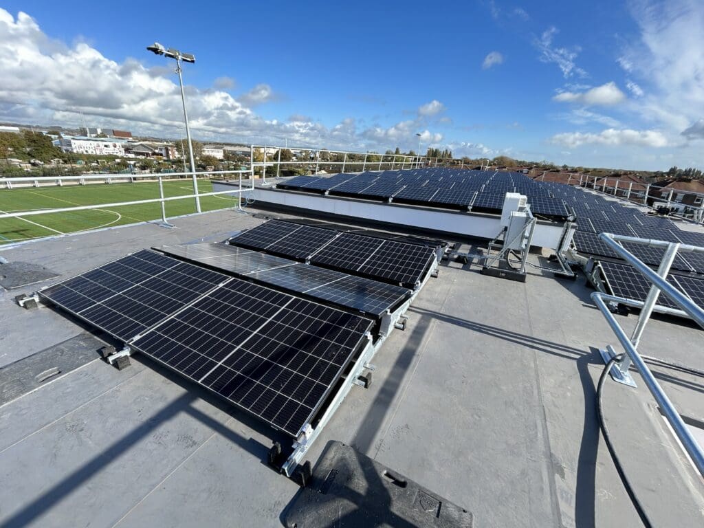 Flat roof solar panels on community football training grounds
